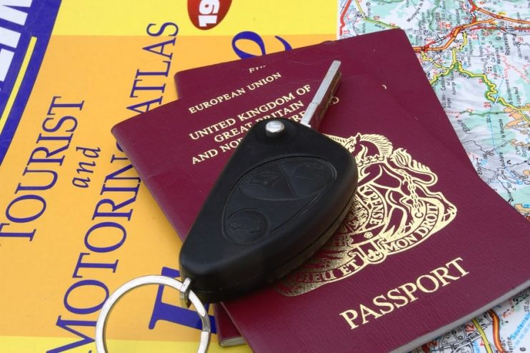 car key travel documents and map for driving abroad