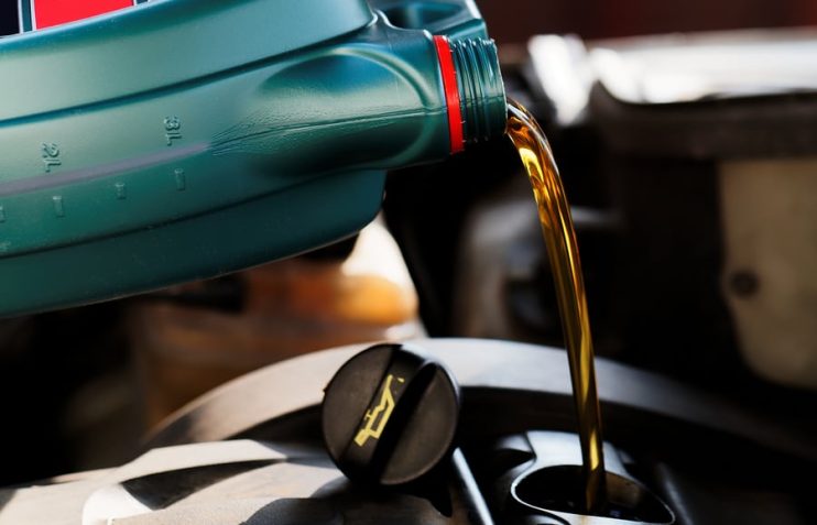 oil being poured into a car during servicing