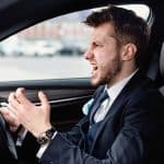 Angry Driver Concept. Aggressive Mad Man In Suit Driving Car In