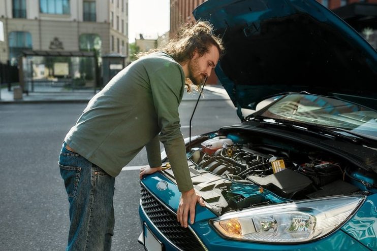 man inspecting a car after a stall