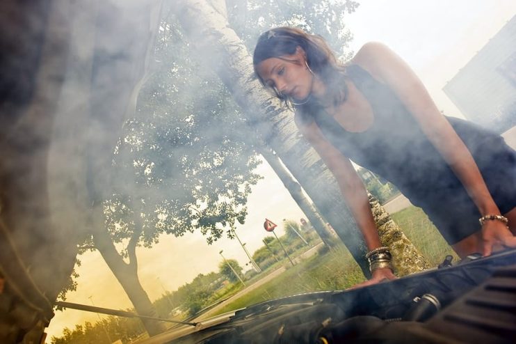 woman looking at smoke from a car