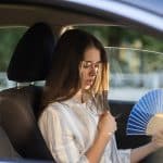 Exhausted Young Woman Driver With Hand Fan Suffering From Heat I