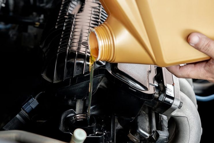 pouring oil into an engine during maintenance