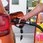 Pumping Gasoline Fuel In Orange Car At A Gas Station. To Fill Ca