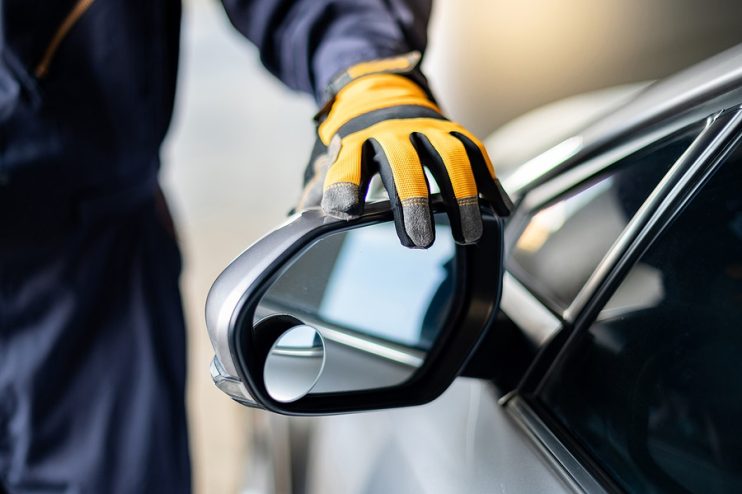 technician replacing a wing mirror