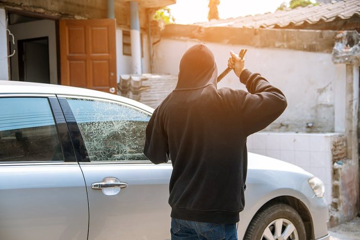 thief breaking a car window