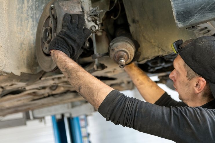 Mechanic fitting drive axle into a hub