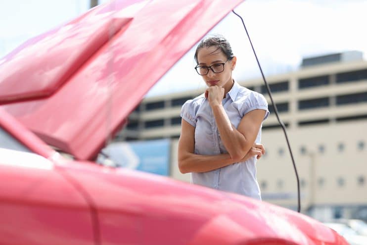 Woman checking car engine