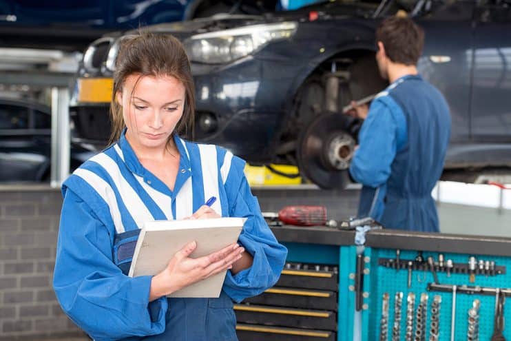 Mechanic inspecting car. 