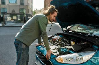 man inspecting a car after a stall